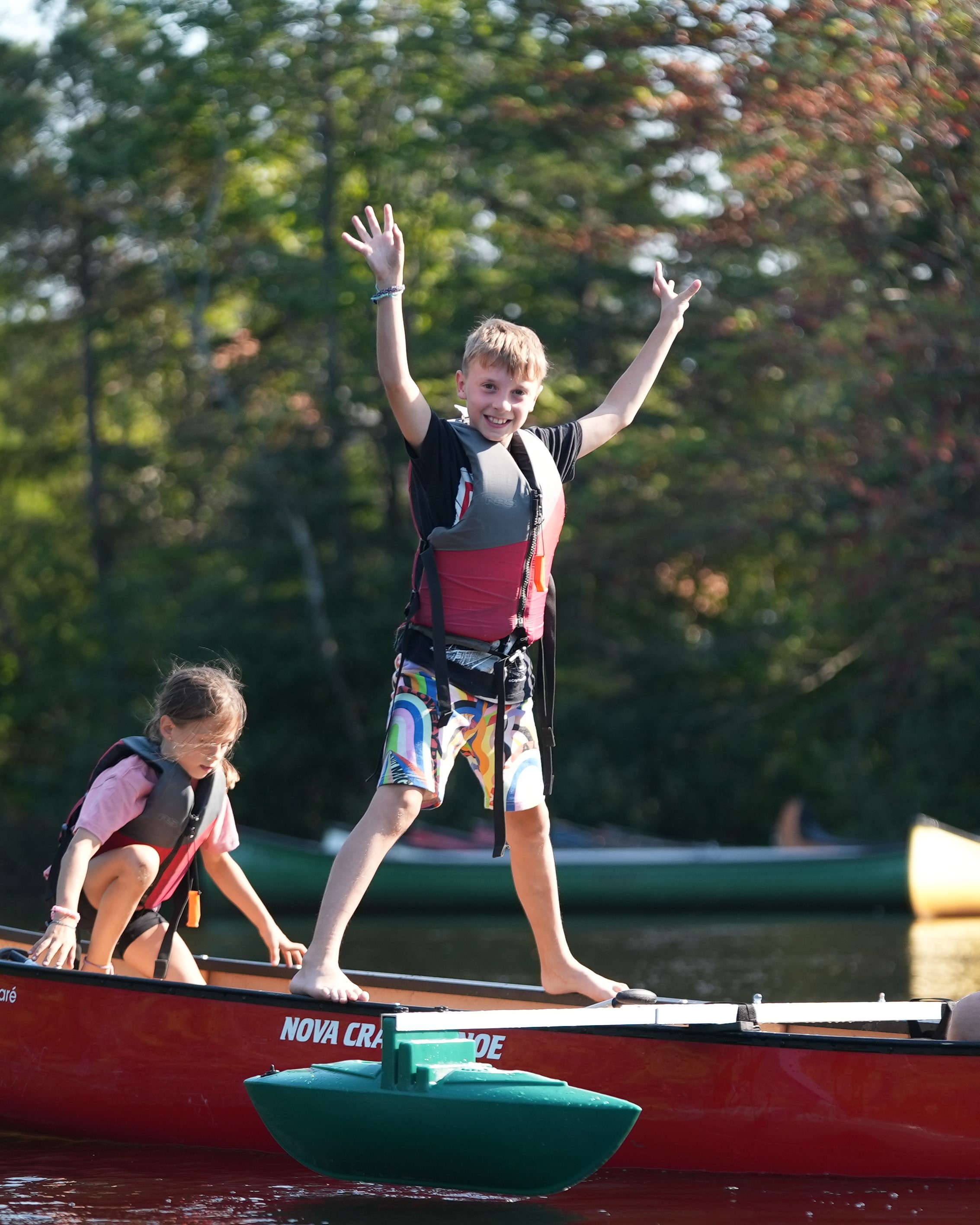 Enfant heureux debout sur les plats-bords d'un canot