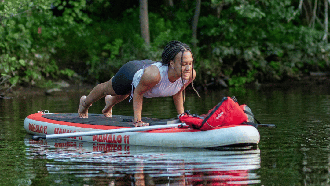 Position de yoga sur une planche à pagaie sur l'eau