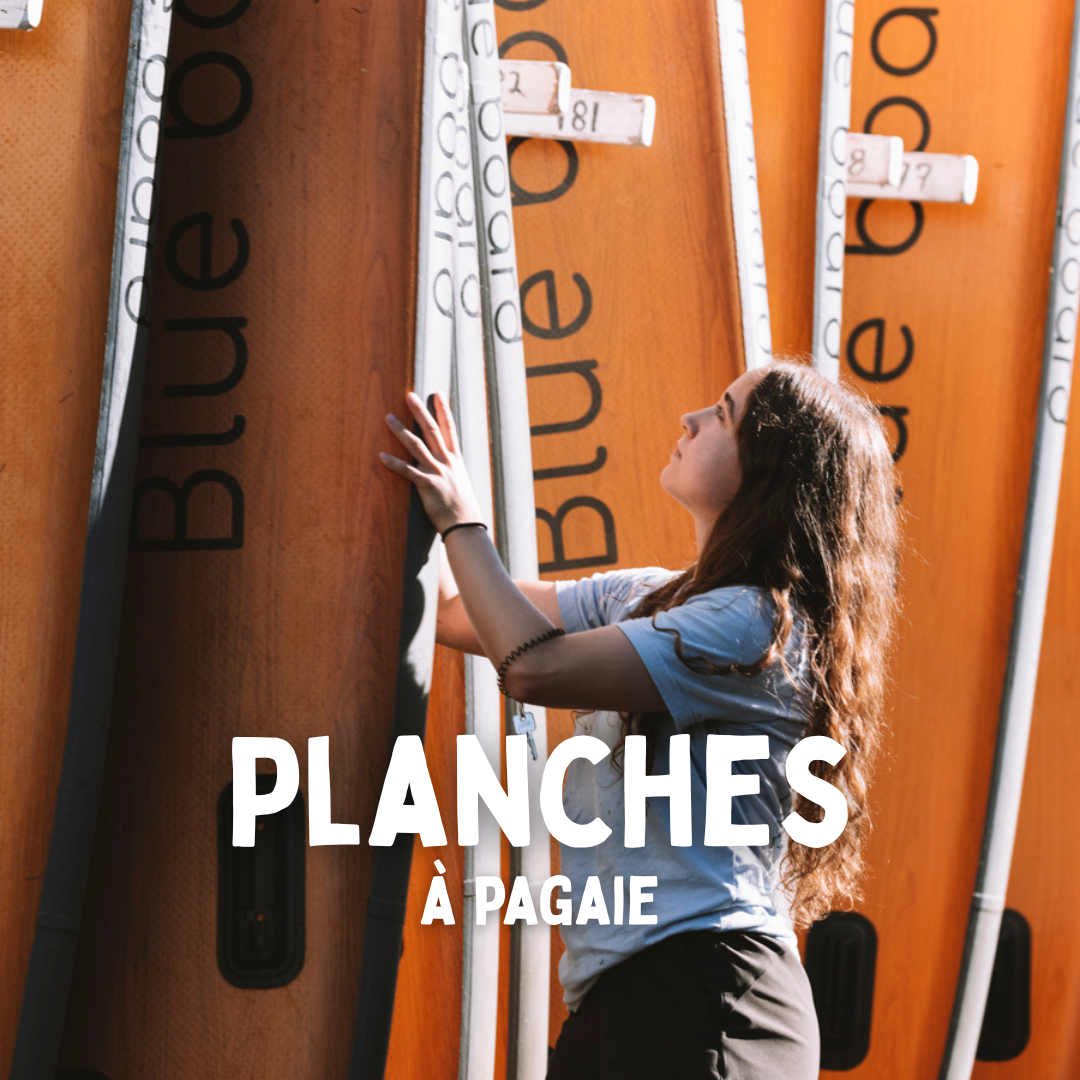 Jeune femme qui range une planche à pagaie