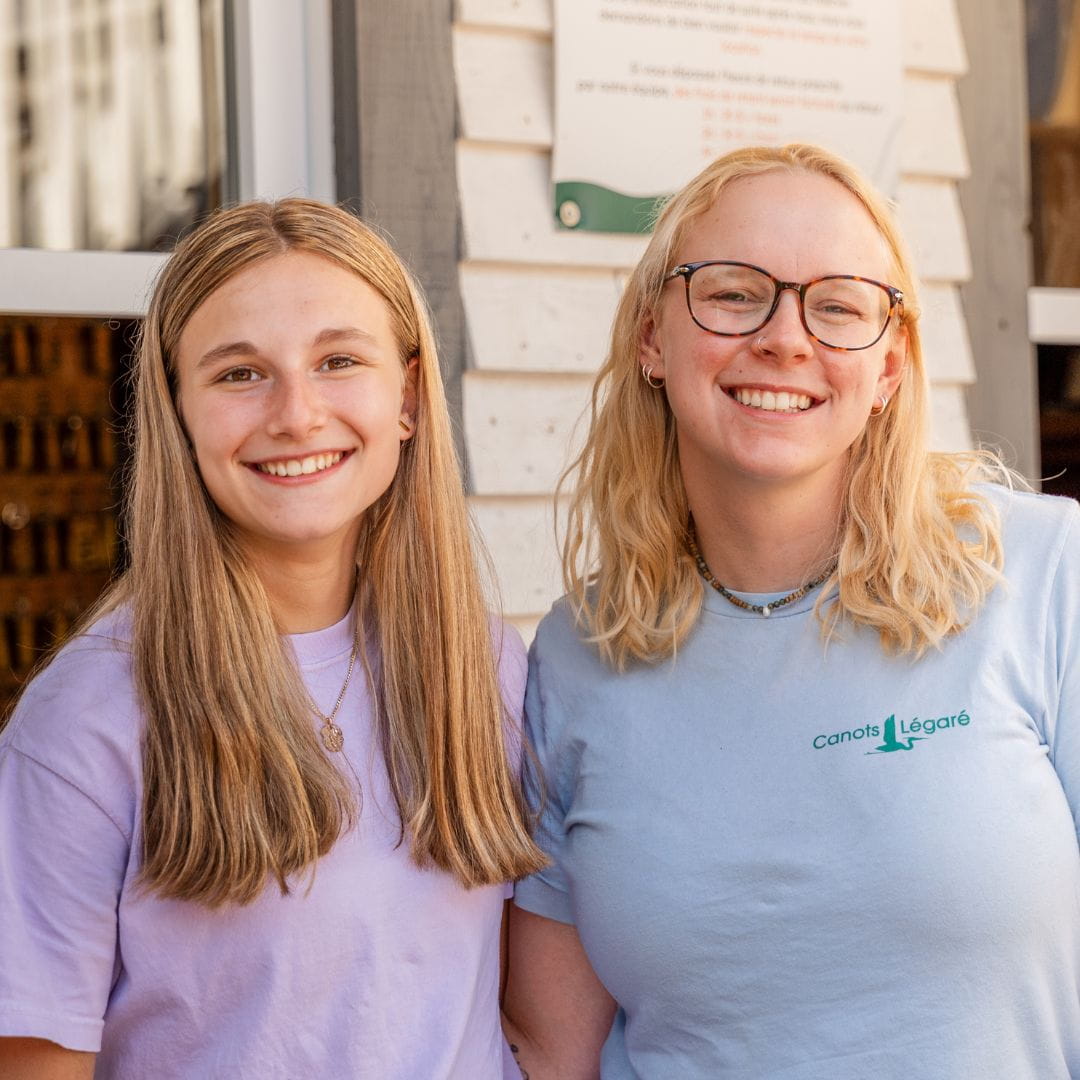 Deux employées souriantes chez Canots Légaré par une journée ensoleillée