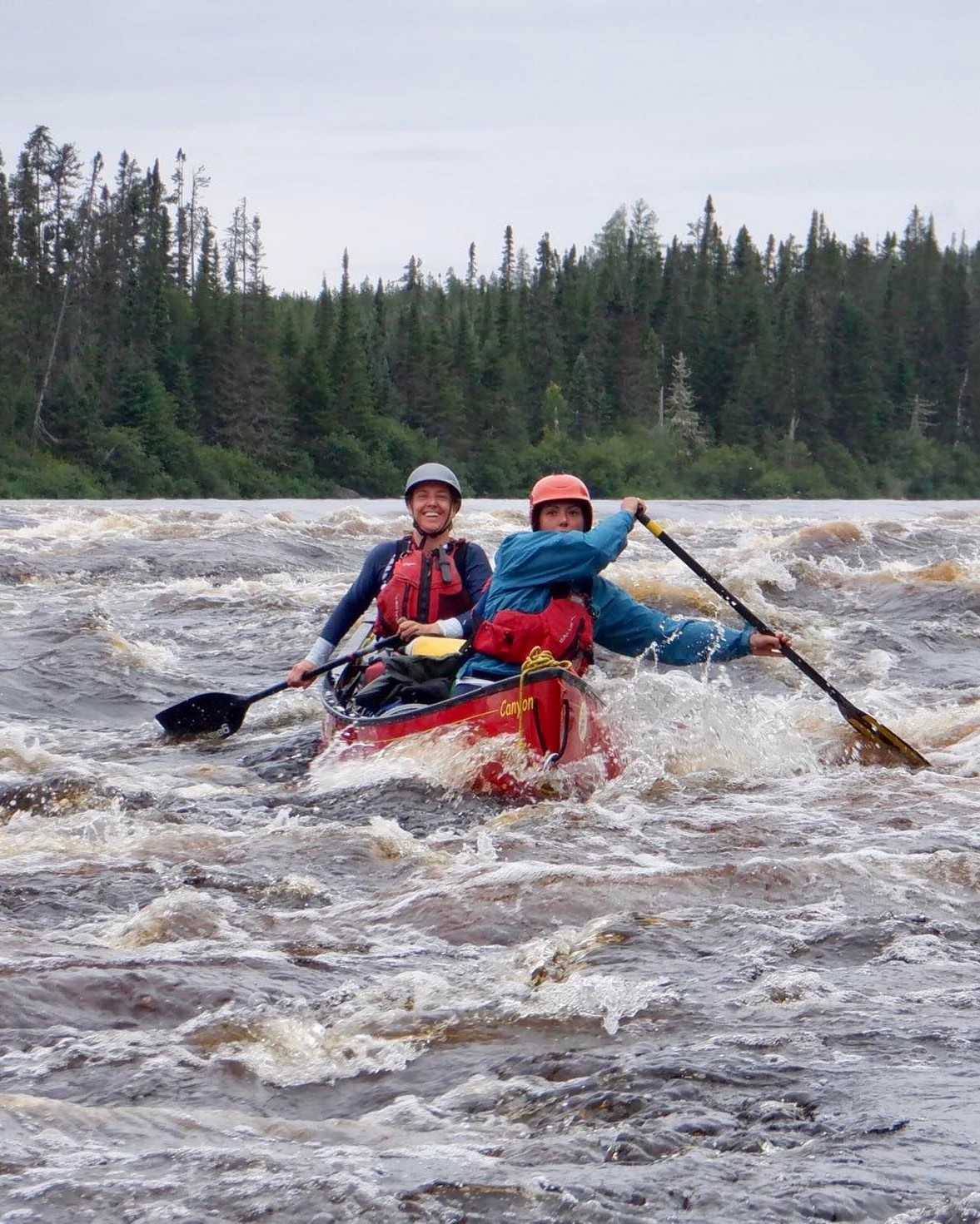 Canot Canyon avec deux pagayeur sur une rivière en eau vive